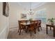 Traditional dining room features a wooden table, chandelier, and natural light from a window with plantation shutters at 315 Clubview Rd, Summerville, SC 29485