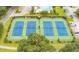 Aerial view of four well-maintained tennis courts surrounded by lush landscaping in a vibrant community at 315 Clubview Rd, Summerville, SC 29485