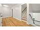Bright hallway with hardwood floors and staircase featuring modern black railing at 317 Sabal Palmetto Ct, Moncks Corner, SC 29461