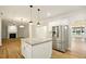 Kitchen with island featuring white cabinets with gold hardware, stainless steel fridge and granite countertop island at 317 Sabal Palmetto Ct, Moncks Corner, SC 29461