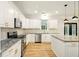 Bright eat-in kitchen with white cabinetry, stainless appliances and granite countertops at 317 Sabal Palmetto Ct, Moncks Corner, SC 29461