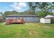 Backyard view of a deck, home's back wall, a storage shed under a blue sky, and lush green lawn at 323 Amy Dr, Goose Creek, SC 29445