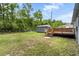 Backyard view of wooden deck leading to a storage shed under a cloudy blue sky and mature trees at 323 Amy Dr, Goose Creek, SC 29445