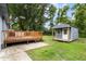 This backyard view displays a wooden deck leading to a storage shed and a large grassy area at 323 Amy Dr, Goose Creek, SC 29445