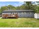 View of the home's backyard with a deck, lawn and blue painted siding under a cloudy blue sky at 323 Amy Dr, Goose Creek, SC 29445