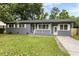Charming gray brick ranch-style home with well-maintained front yard, walkway and covered porch at 323 Amy Dr, Goose Creek, SC 29445
