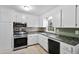 Kitchen with white cabinets and modern stainless steel appliances under natural lighting at 323 Amy Dr, Goose Creek, SC 29445