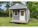 A storage shed with blue painted siding and a white front door provides extra space in this backyard at 323 Amy Dr, Goose Creek, SC 29445