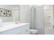 A clean bathroom featuring a shower with a striped curtain, a white vanity, and decorative artwork at 328 Tiliwa St, Summerville, SC 29486
