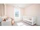 Bright Bedroom with a white crib, a comfortable wicker chair, and a window letting in natural light at 328 Tiliwa St, Summerville, SC 29486