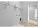 Functional laundry room featuring white walls, tile flooring, wire shelving, and convenient access to appliances and utilities at 334 Cicadas Song Dr, Moncks Corner, SC 29461