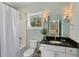 Well-lit bathroom with a shower-tub combo, complemented by granite countertops and traditional fixtures at 3426 Acorn Drop Ln, Johns Island, SC 29455
