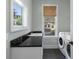 Well-lit laundry room with modern washer and dryer, complemented by granite countertops and outdoor views at 3426 Acorn Drop Ln, Johns Island, SC 29455