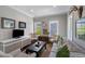 Cozy living room with striped sofa, floral chairs, and abundant natural light from multiple windows at 3426 Acorn Drop Ln, Johns Island, SC 29455