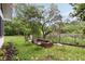 Backyard featuring a brick fire pit with seating surrounded by lush landscaping and mature trees at 36 Nicholson St, Charleston, SC 29407
