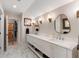 Bathroom with double vanity, marble floors, and warm sconce lighting at 36 Nicholson St, Charleston, SC 29407