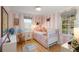 Charming bedroom with pink striped walls, white trim, and hardwood floors at 36 Nicholson St, Charleston, SC 29407