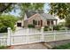 Quaint brick home featuring a white picket fence and detached garage at 36 Nicholson St, Charleston, SC 29407