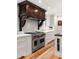 Gourmet kitchen with a large stainless steel range and custom dark wood range hood at 36 Nicholson St, Charleston, SC 29407