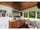 Outdoor kitchen with grill, wood ceiling, and adjacent seating area for backyard entertaining at 36 Nicholson St, Charleston, SC 29407