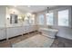 Bright bathroom with double sinks, vanity, gorgeous lighting fixtures, and a stand alone tub at 3803 Palm Blvd, Isle of Palms, SC 29451