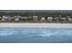 Coastal homes line a beautiful beach, with the ocean waves crashing gently on the shore at 3803 Palm Blvd, Isle of Palms, SC 29451
