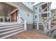 Exterior deck featuring wood flooring, cable railing, stairs, covered porch, and mature trees at 3803 Palm Blvd, Isle of Palms, SC 29451