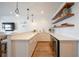 Wet bar with white marble counters, a beverage refrigerator, and open shelves set against a wood paneled wall at 3803 Palm Blvd, Isle of Palms, SC 29451