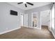 Bedroom features a ceiling fan, television, and doors to the bathroom and hallway at 4003 Radcliffe Place Dr # B6, Charleston, SC 29414