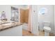 Bright bathroom featuring a granite vanity, tile floors, a walk-in shower and a round window above toilet at 4009 E Amy Ln, Johns Island, SC 29455