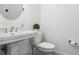 Bathroom featuring a pedestal sink, round mirror, toilet, neutral paint and flooring, and classic fixtures at 4009 E Amy Ln, Johns Island, SC 29455