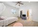 Bedroom featuring carpeted floors, ceiling fan, natural light, and an open ensuite bathroom at 4009 E Amy Ln, Johns Island, SC 29455