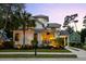 Beautiful home with a manicured lawn, covered porch, palm trees, and a side carport and driveway at 4009 E Amy Ln, Johns Island, SC 29455