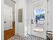 Hallway leading to the garage features tile flooring, white trim, and plenty of natural light at 4009 E Amy Ln, Johns Island, SC 29455