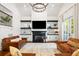 Bright living room featuring a fireplace with TV, built-in shelves, and access to outdoor patio at 4009 E Amy Ln, Johns Island, SC 29455
