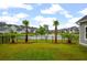 Well-manicured backyard with tropical landscaping overlooking a pond at 4129 Maidstone Dr, Mount Pleasant, SC 29466