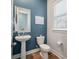 Stylish powder room with a pedestal sink and an accent wall with fun art at 4129 Maidstone Dr, Mount Pleasant, SC 29466