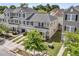 Eye-level aerial view of well-manicured lawn and exteriors of townhomes set in residential community at 4235 Scharite St, Charleston, SC 29414