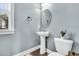 Charming powder room featuring a pedestal sink, oval mirror and wood-look flooring at 4235 Scharite St, Charleston, SC 29414