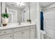 Well-lit bathroom featuring a vanity with white cabinets and a shower with blue curtain at 4235 Scharite St, Charleston, SC 29414