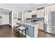 Well-lit kitchen island features a sink, stainless steel refrigerator, and barstool seating at 4235 Scharite St, Charleston, SC 29414