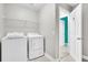 Bright laundry room features a washer, dryer, and shelving; door leads to closet at 4235 Scharite St, Charleston, SC 29414