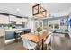 An open living space with a kitchen island, dining table, and views to the living room bathed in sunlight at 4235 Scharite St, Charleston, SC 29414
