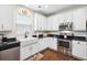 Well-lit kitchen with white cabinets, stainless steel appliances, a farmhouse sink, and hardwood floors at 428 Cabrill Dr, Charleston, SC 29414