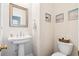 Cozy powder room with pedestal sink, gold mirror, and beach-themed decor at 428 Cabrill Dr, Charleston, SC 29414