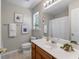 Bathroom with a wooden vanity, large mirror, framed artwork, and a window to let light in at 432 Doane Way, Wando, SC 29492