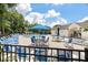 Community pool area with several lounge chairs and tables with umbrellas by the pool at 432 Doane Way, Wando, SC 29492
