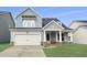 Charming two-story home with light blue siding, a white garage door, and a well-manicured lawn at 459 White Magnolia St, Moncks Corner, SC 29461
