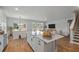 Open-concept kitchen with a center island, white cabinets, stainless appliances, and hardwood floors at 459 White Magnolia St, Moncks Corner, SC 29461