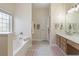 Bathroom featuring double sink vanity, garden tub, large window, and neutral paint at 465 Blue Dragonfly Dr, Charleston, SC 29414